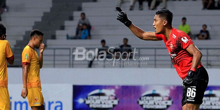 Kiper Sriwijaya FC, Sandi Firmansyah, memberi instruksi kepada rekan setimnya saat melawan Persebaya