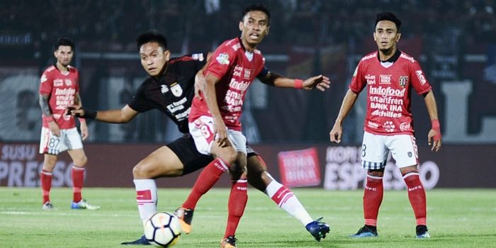 Kapten Bali United, Fadil Sausu (tengah) dikawal ketat bek Persipura, Muhammad Taher (jersey hitam) 