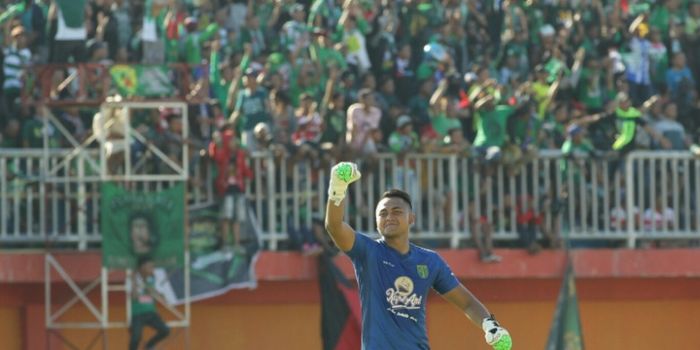 Kiper Persebaya, Dimas Galih mengepalkan tangan dengan latar belakang Bonek saat dijamu Persepam Mad