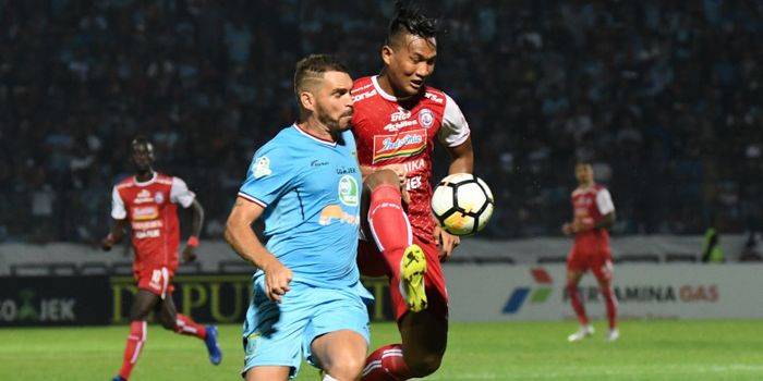 Striker Arema FC, Ahmad Nur Hardianto berebut bola dengan bek Persela Lamongan, Wallace Costa di Sta