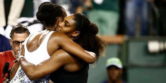 Venus Williams (baju putih) dan Serena Williams (baju hitam) saat berpelukan usai keduanya bertemu p