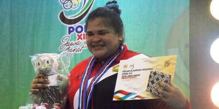 Lifter putri provinsi Aceh, Nurul Akmal, berpose dengan medali emas yang didapat dari cabang olahrag