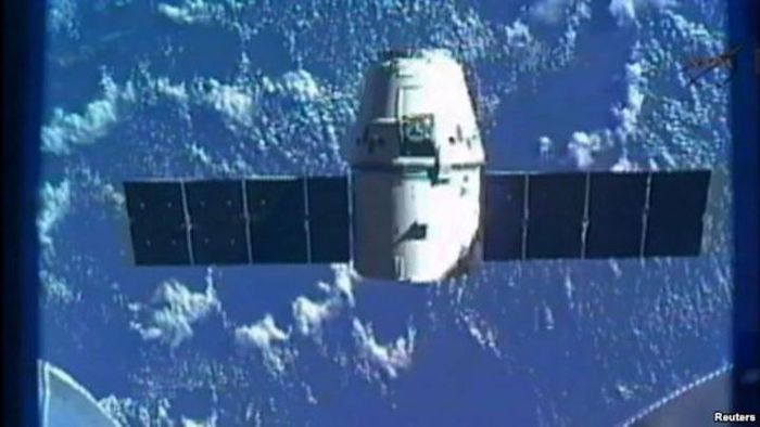 Pesawat kargo SpaceX, Dragon, terlihat di ujung tangan robot Canadarm2 ISS pada pengiriman pasokan a