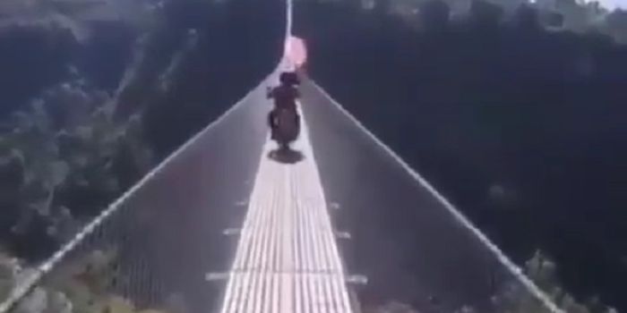 Dua pengendara motor melintasi jembatan yang bikin jantung copot.