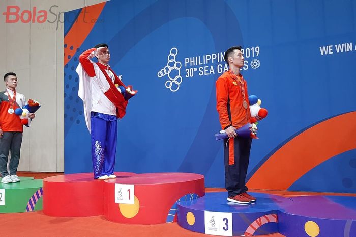 Pewushu putra Indonesia, Edgar Xavier Marvelo, saat upacara pemberian medali emas SEA Games 2019 nomor daoshu/gunshu combined putra, Selasa (3/12/2019).
