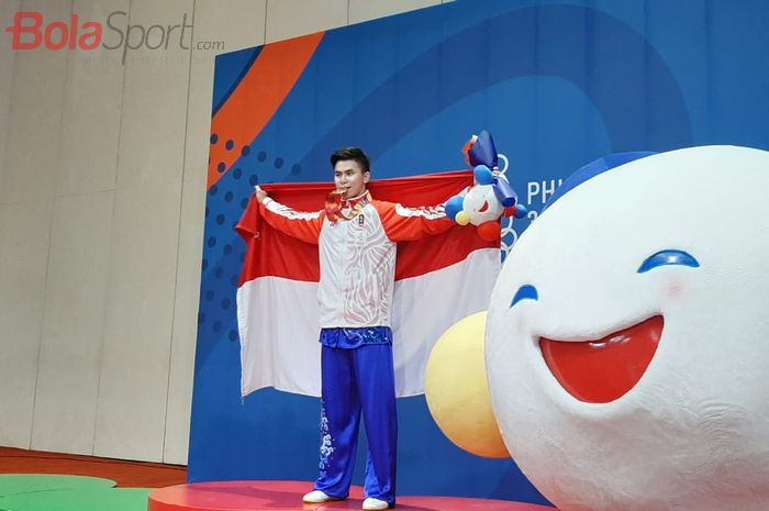 Pewushu putra Indonesia, Edgar, Xavier Marvelo, berpose dengan medali emas yang diraoh dari nomor nomor daoshu/gunshu combined putra SEA Games 2019 di WTC, Manila, Selasa (3/12/2019).