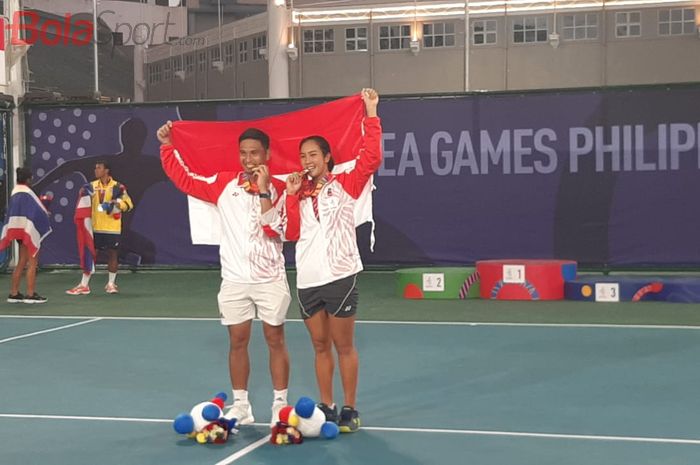 Petenis ganda campuran Indonesia, Christopher Rungkat/Aldila Sutjiadi, berpose dengan medali emas SEA Games 2019 di Rizal Memorial Tennis Center, Manila, Sabtu (7/12/2019).