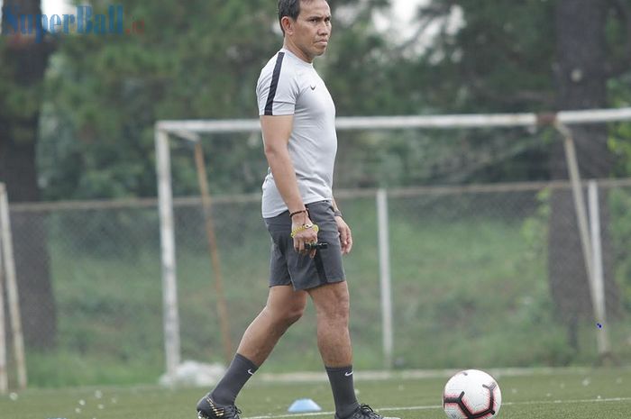 Pelatih Timnas U-16 Indonesia Bima Sakti mengamati latihan pasukannya di National Youth Training Center (NYTC), Sawangan, Depok, Jawa Barat, Senin (13/5/2019), untuk Piala AFF U-16 2019.  