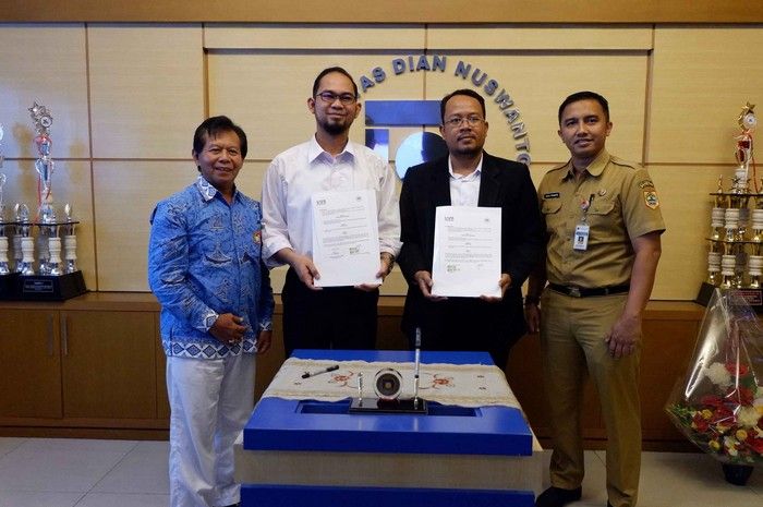 Nicodemus Widiutomo, Udinus Esports Program builder (second from right) signs a work agreement