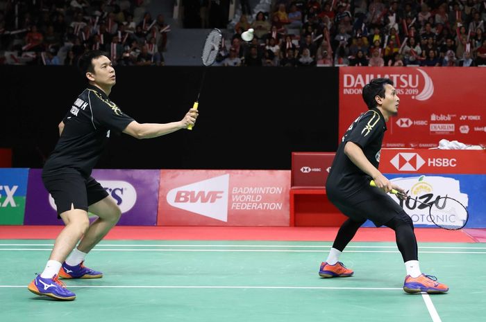 Pasangan ganda putra Indonesia, Mohammad Ahsan/Hendra Setiawan, mengembalikan kok ke arah Han Chengkai/Zhou Haodong (China) pada babak semifinal Indonesia Masters 2019 di Istora Senayan, Jakarta, Sabtu (27/1/2019).