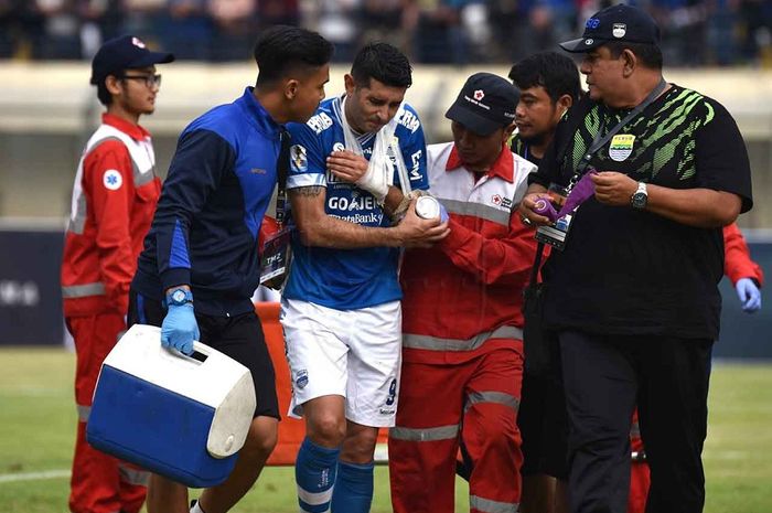 Esteban Vizcarra dibawa keluar lapangan sambil meringis kesakitan karena cedera saat Persib Bandung menjamu Arema  FC dalam leg pertama babak 16 besar Piala Indonesia di Stadion Si Jalak Harupat, Kabupaten Bandung, Senin (18/2/2019) sore WIB.
