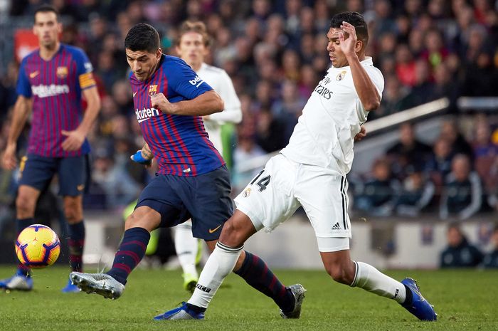 Gelandang Real Madrid, Casemiro, berupaya menahan laju penyerang Barcelona, Luis Suarez, pada laga El Clasico, Oktober 2018.    