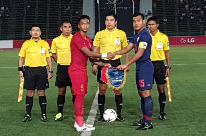 Kapten timnas U-22 Indonesia, Bagas Adi (merah) dan kapten timnas U-22 Thailand, Saringkan Promsupa sali berjabat tangan sebelum final Piala AFF U-22 2019, 26 Februari 2019.