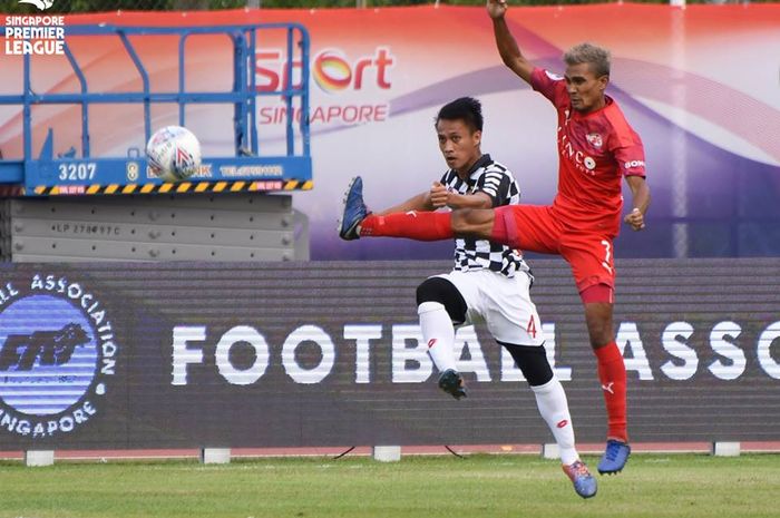 Aksi dua pemain dari Home United, Aqhari Abdullah (merah), dan bek DPMM FC, Fakharrazi Hassan pada pekan pertama Liga Singapura 2019, 3 Maret 2019. 