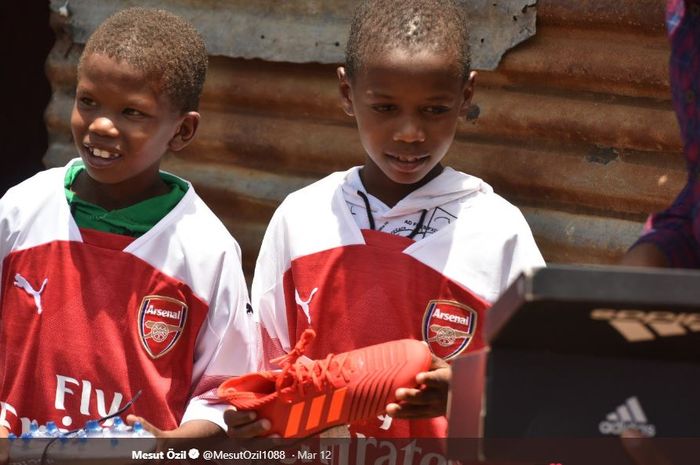 Dua bocah asal Kenya mendapatkan cinderamata dari pemain andalan Arsenal, Mesut Oezil.
