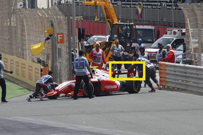 Pembalap Prema Racing asal Indonesia, Sean Gelael, dibantu petugas saat mobilnya mengalami kerusakan pada balapan pertama Formula 2 Bahrain di Sirkuit Sakhir, Bahrain, Sabtu (30/3/2019).