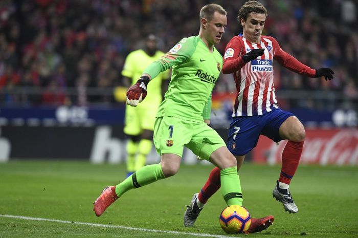 Kiper Barcelona, Marc-Andre Ter Stegen mengontrol bola dengan dibayang-bayangi penyerang Atletico Madrid, Antoine Griezmann, pada November 2018.