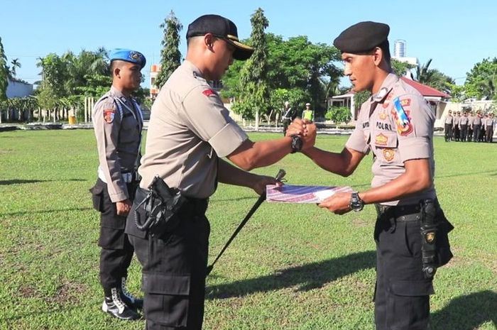 Brigadir Teuku Putra mendapat penghargaan dari Kapolres Aceh Utara atas tugasnya menjaga PPK sambil menidurkan anaknya.