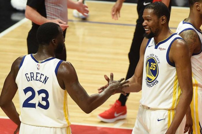 Pebasket bintang Golden State Warriors, Kevin Durant, melakukan tos dengan rekan setimnya, Draymond Green.