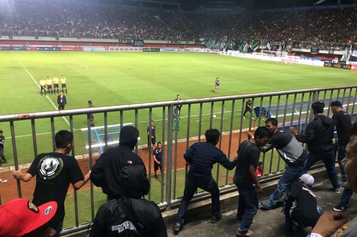 Suporter PSS Sleman mencoba melakukan kekerasan ke pemain Arema FC.