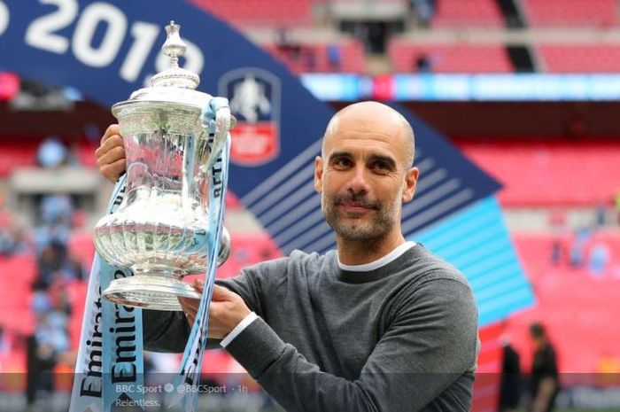 Manajer Manchester City, Pep Guardiola, bersama trofi Piala FA musim 2018-2019.