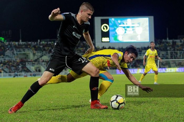 Bek Terengganu FC, Igor Zonjic (kaus hitam) saat berhasil merebut bola dari pemain Pahang FA pada laga Liga Super Malaysia 2019 di Stadion Darul Makmur, Kuantan, 18 Mei 2019.