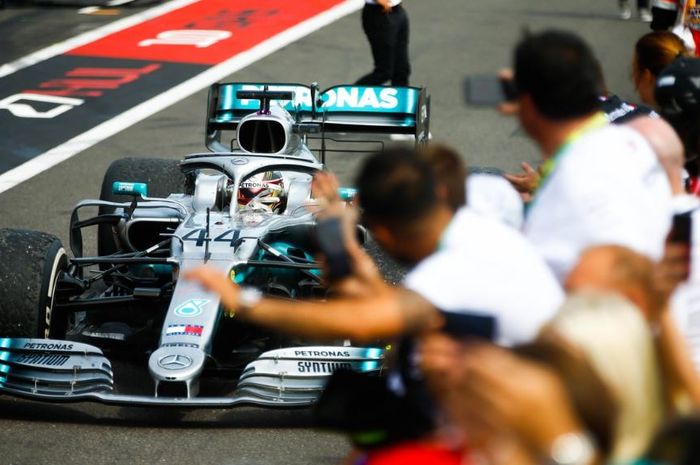 Pembalap Mercedes, Lewis Hamilton disambut para krunya usai menangi seri F1 Prancis 2019, Minggu (23/6/2019)
