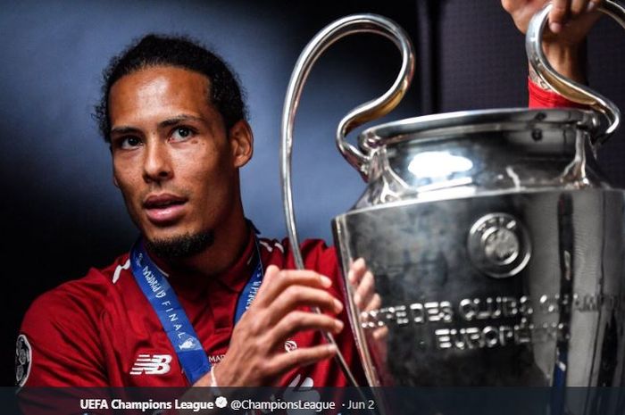 Bek Liverpool FC, Virgil van Dijk, memegang trofi Liga Champions. 