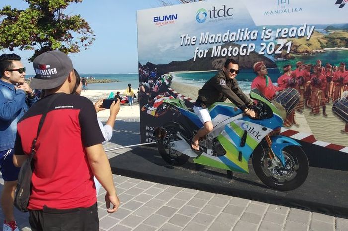 Pengunjung pantai Kuta Mandalika berpose di spot foto dengan miniatur motor MotoGP