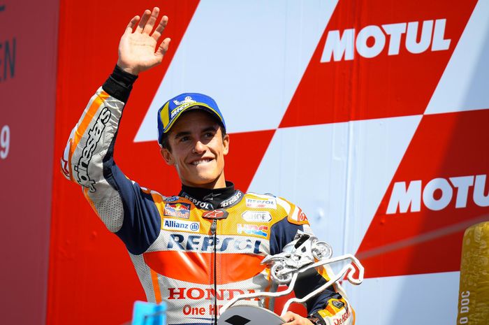 Pembalap Repsol Honda, Marc Marquez, melambaikan tangan di podium MotoGP Belanda di Sirkuit Assen, Minggu (30/6/2019).