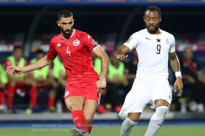 Penyerang Ghana, Jordan Ayew (kanan), bertarung dengan bek Tunisia, Yassine Meriah, dalam babak 16 besar Piala Afrika 2019 di Stadion Ismailia, 8 Juli 2019.