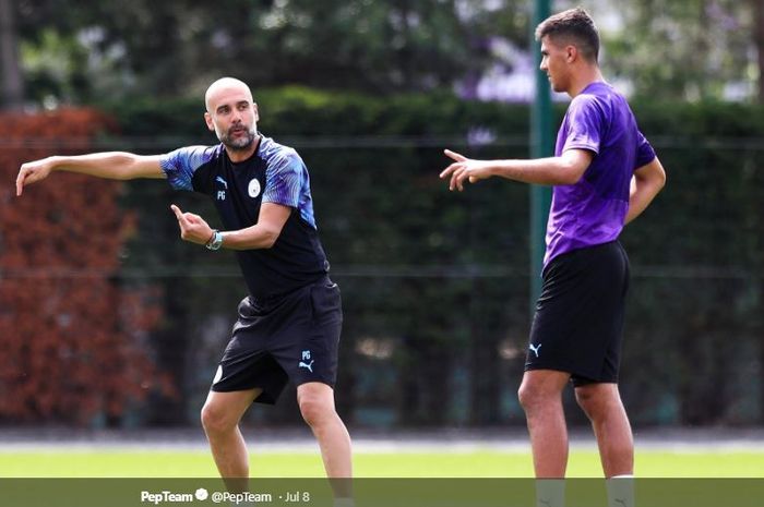 Pelatih Manchester City, Pep Guardiola, memberi instruksi kepada Rodri Hernandez dalam sesi latihan pra-musim 2019.