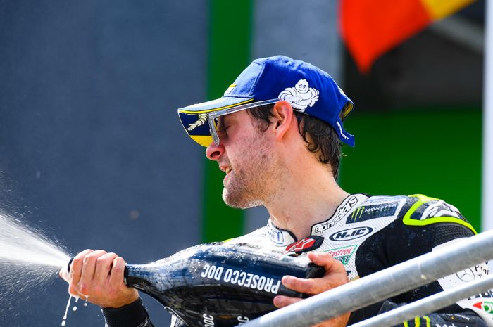 Pembalap LCR Honda, Cal Crutchlow, menyiram sampanye di podium MotoGP Jerman di Sachsenring, Minggu (7/7/2019).