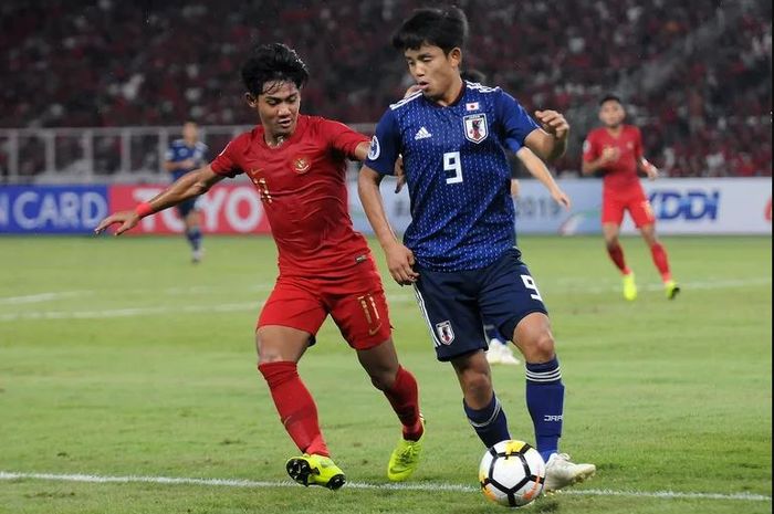 Bek kiri timnas U-19 Indonesia, Firza Andika menjaga ketat bintang timnas U-19 Jepang, Takefusa Kubo, pada laga perempat final Piala Asia U-19 2018 di Stadion Utama Gelora Bung Karno, Jakarta, Minggu (28/10/2018).