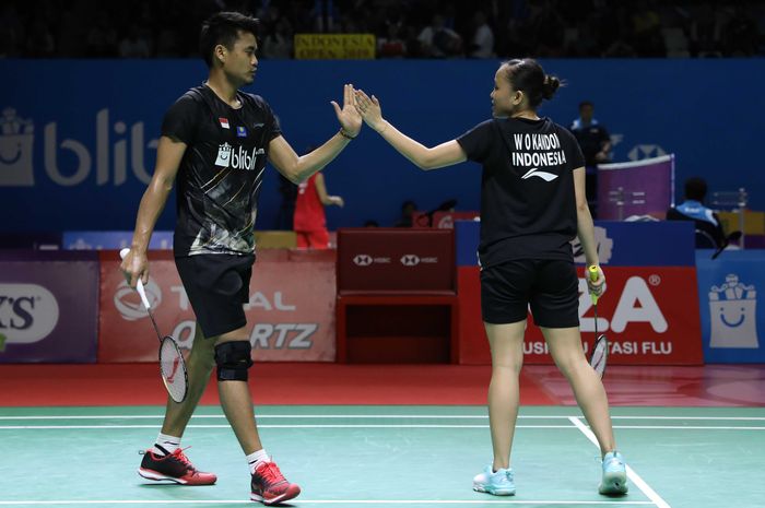 Pasangan ganda campuran Indonesia, Tontowi Ahmad/Winny Oktavina Kandow, melakukan tos setelah memastikan diri lolos ke babak perempat final Indonesia Open 2019 di Istora Senayan, Jakarta, Kamis (18/7/2019).