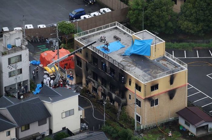 Pemandangan dari atas menunjukkan petugas pemadam kebakaran dan tim penolong berada di gedung studio Kyoto Animation Co yang terbakar di Kyoto, Jepang, Kamis (18/7/2019). Lebih dari 20 orang tewas dalam kebakaran yang disengaja itu.  Artikel ini telah tayang di Kompas.com dengan judul 