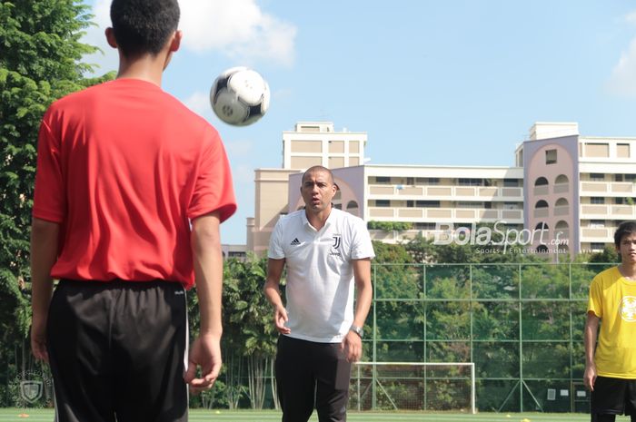 Legenda Juventus, David Trezeguet, melemparkan operan ke salah seorang pemain dari acara Singapore Legacy Project yang diselenggarakan oleh International Champions Cup 2019 di Bendemeer Secondary School, Sabtu (20/7/2019).