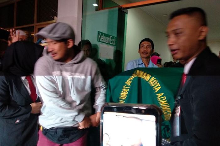 komedian Isa Bajaj beserta keluarga Agung Hercules membawa keranda jenazah Agung Hercules ke dalam ambulance di rumah sakit Dharmais, Jakarta Barat, Kamis (1/8/2019).
