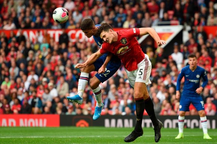 Harry Maguire berduel dengan Christian Pulisic saat MU kontra Chelsea di Old Trafford.