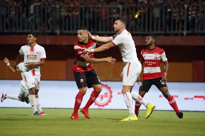 Striker Persija Jakarta, Marko Simic, mendapatkan pengawalan ketat dari bek Madura United, Jaimerson Xavier, pada laga pekan ke-14 Liga 1 2019.