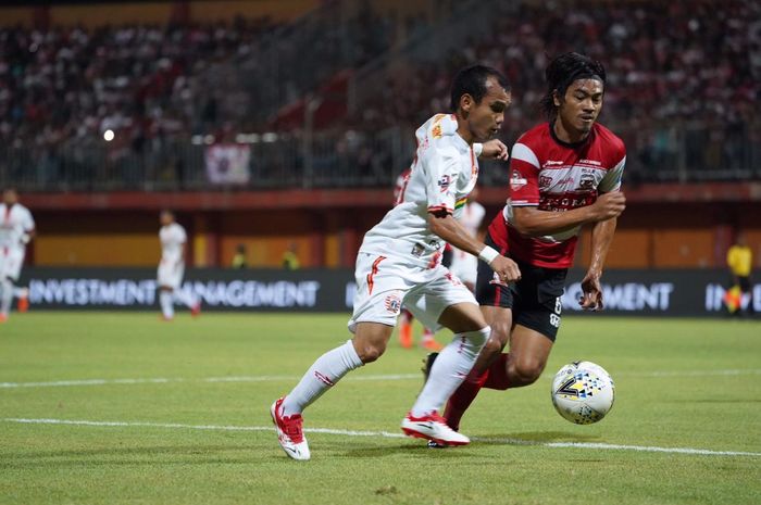 Winger Persija Jakarta, Riko Simanjuntak, mendapatkan pengawalan dari bek Madura United, Rendika Rama, dalam pertemuan kedua tim pada pekan ke-14 Liga 1 2019.