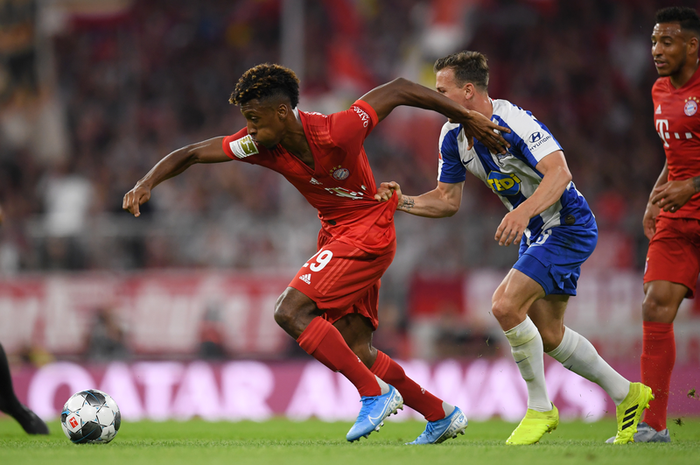 Pemain Bayern Muenchen, Kinglsey Koman (kiri), berduel dengan gelandang Hertha Berlin, Vladimir Darida, saat pertandingan pekan pertama Liga Jerman 2019-2020 di Allianz Arena, 16 August 2019.