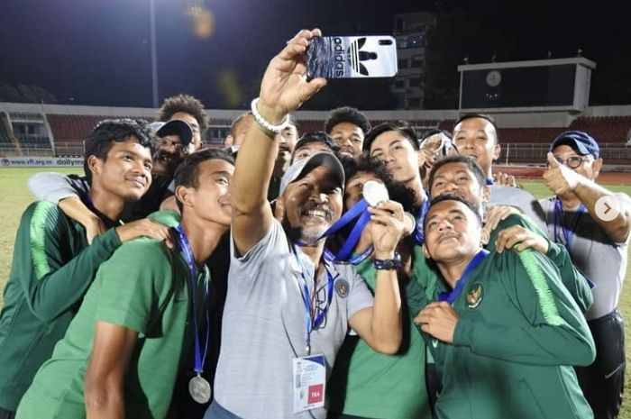 Pelatih Timnas U-18 Indonesia Fakhri Husaini (tengah) berswafoto dengan para pemainnya usai menerima medali peringkat ketiga Piala AFF U-18 2019 di Vietnam, Senin (19/8/2019).