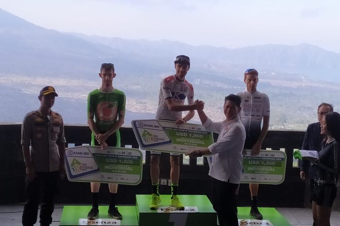 Ketua Umum Pengurus Besar Ikatan Sport Sepeda Indonesia (PB ISSI) Raja Sapta Oktohari, memberikan penghargaan kepada Thomas Lebas (tengah) dari Kinan Cycling Team (Jepang) di Batur Geopark, Jumat (23/8/2019).
