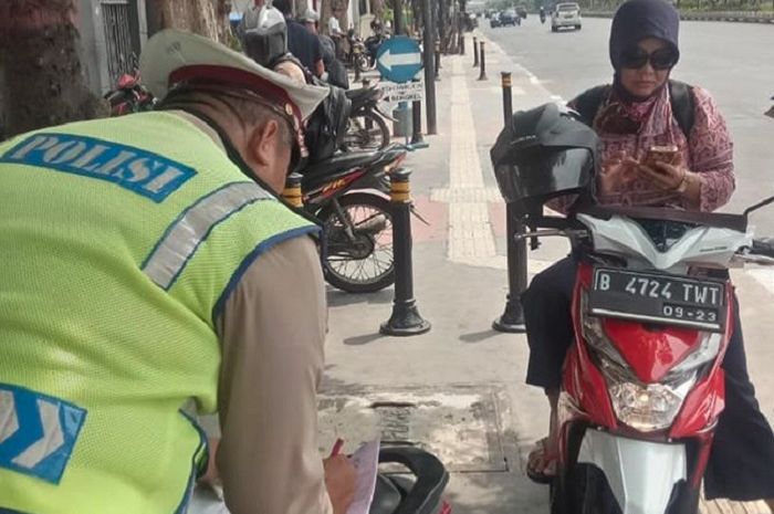 Emak Emak Pengendara Skutik Tertunduk Sambil Mainan Hape