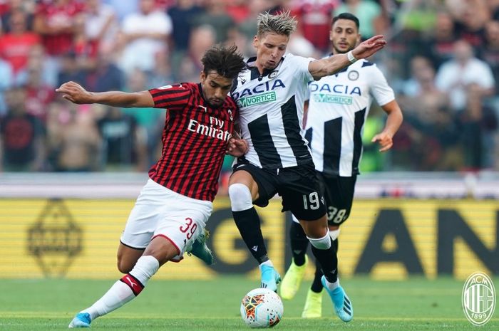 Lucas Paqueta dan Jens Strygen Larsen saling berebut bola pada pertandingan Udinese melawan AC Milan pada pekan perdana Liga Italia di Stadion Dacia Arena, Minggu (25/8/2019).