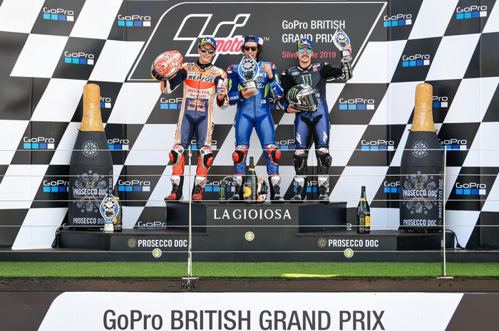 Dari kiri ke kanan, Marc Marquez, Alex Rins, dan Maverick Vinales berpose di podium MotoGP Inggris di Sirkuit Silverstone, Minggu (25/8/2019).