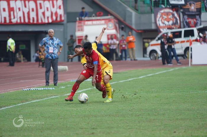 Kapten Persija Jakarta, Ramdani Lestaluhu, berduel dengan pemain Semen Padang