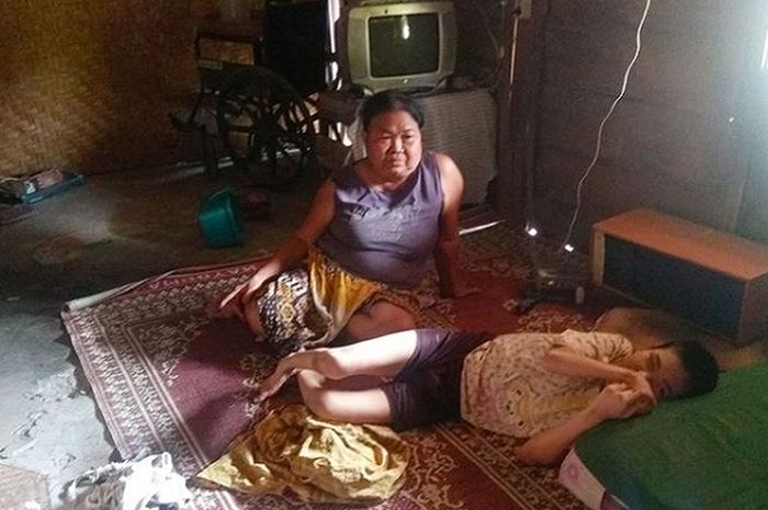 Suyati bersama anaknya Rini (45) yang menderita lumpuh. Selama 45 tahun kegiatan anaknya hanya berbaring di kamar dan menonton televisi, Rabu (16/10/2019)