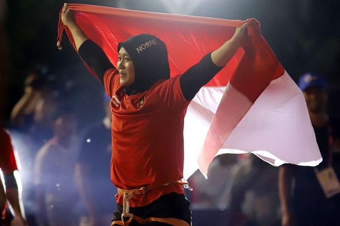 Atlet panjat tebing Indonesia Aries Susanti Rahayu mengibarkan Bendera Merah Putih setelah berhasil meraih medali emas pada kategori speed Asian Games 2018 di Arena Panjat Tebing Jakabaring Sport City, Palembang, Sumatera Selatan, Kamis (23/8/2018).